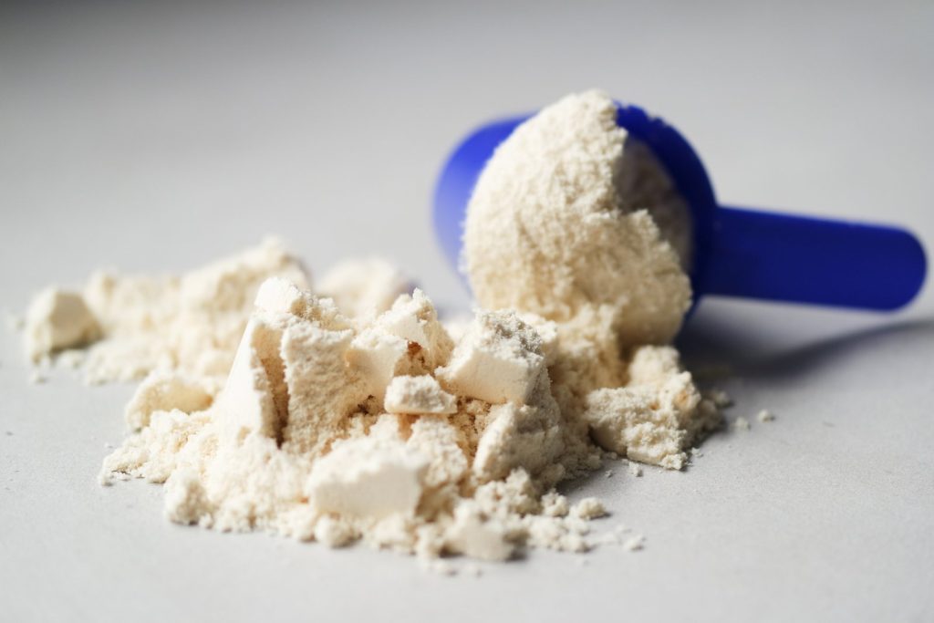 Bột whey protein trên muỗng đong, chụp cận cảnh