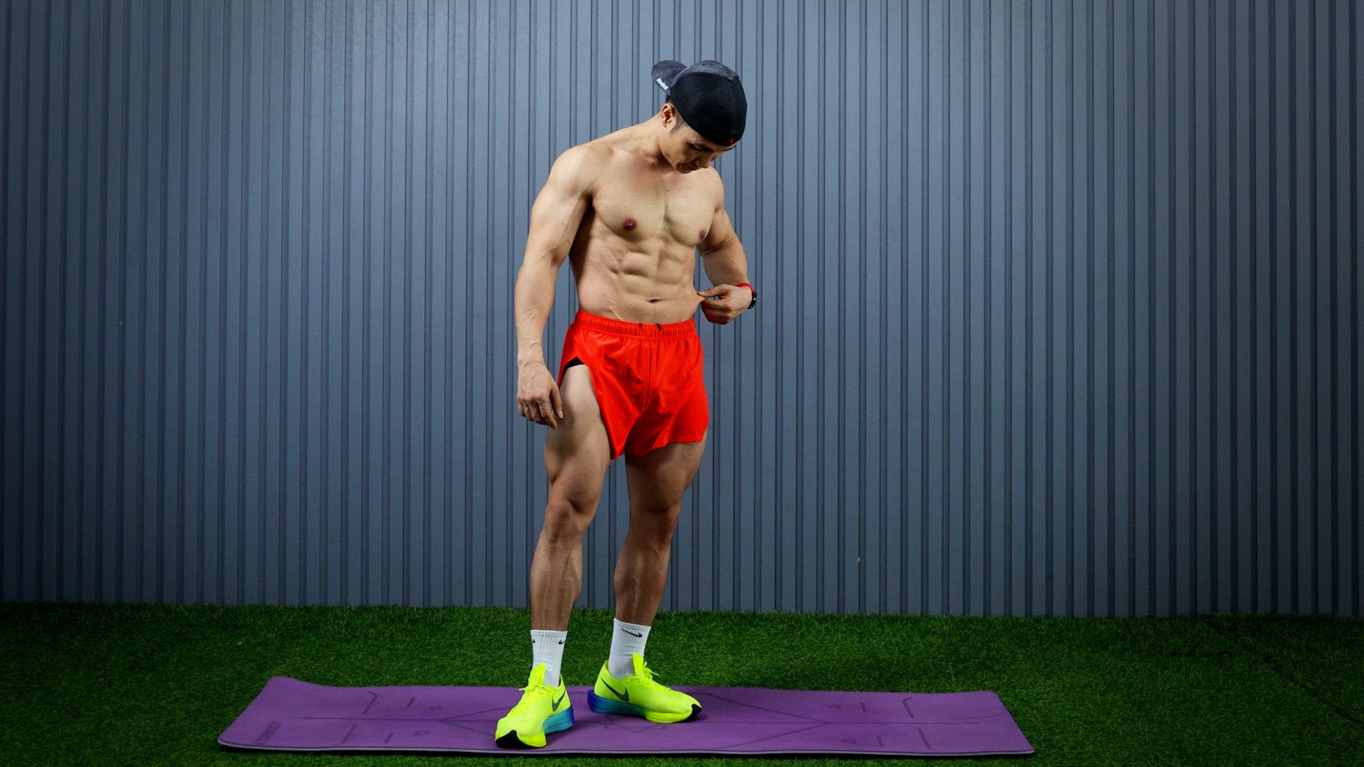 Nguyễn Bảo Bằng cởi trần đứng trên thảm tập, cơ bụng và cơ đùi rõ nét