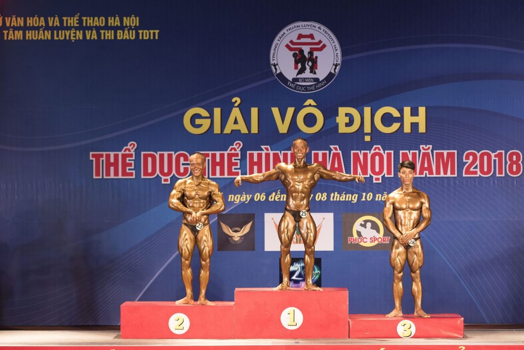 Nguyễn Bảo Bằng đứng trên bục nhận huy chương bạc hệ chuyên nghiệp tại Giải Thể hình mở rộng Hà Nội 10/2018
