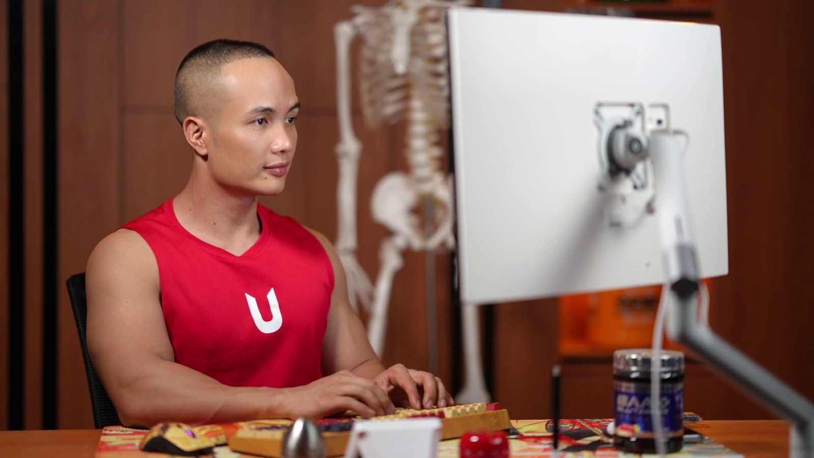 Người huấn luyện viên ngồi trước màn hình máy tính, xem lại nội dung học viên gửi
