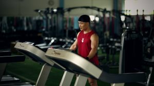 Mở phòng gym cần giấy phép gì? 2 loại giấy và mức phạt Nguyễn Bảo Bằng đứng ở khu máy chạy trong một phòng gym, phía sau là giàn tạ và giá phụ kiện