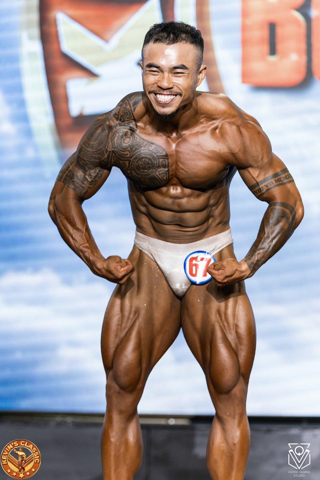 Vận động viên Bodybuilding cơ bắp to, dày, gồng bụng và đùi trên sân khấu Kevin's Classic