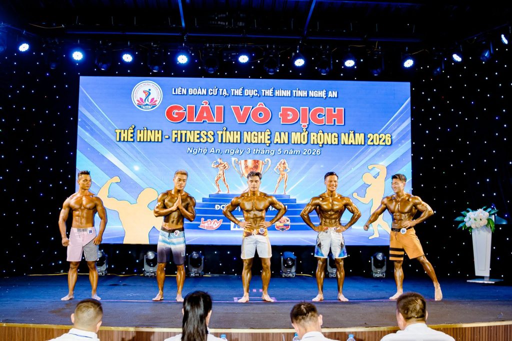Sân khấu giải thể hình Nghệ An 2026 với năm vận động viên men's physique và khán giả phía trước