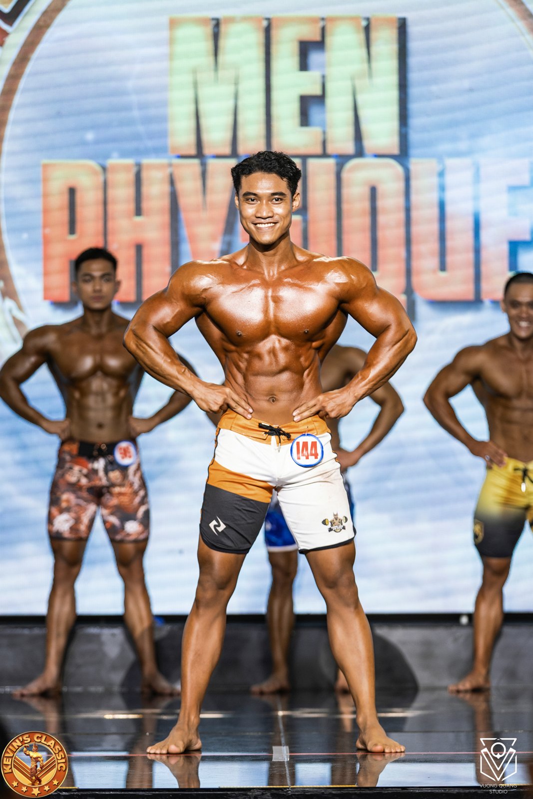 Hàng vận động viên Men Physique so sánh, người đứng giữa tay chống hông