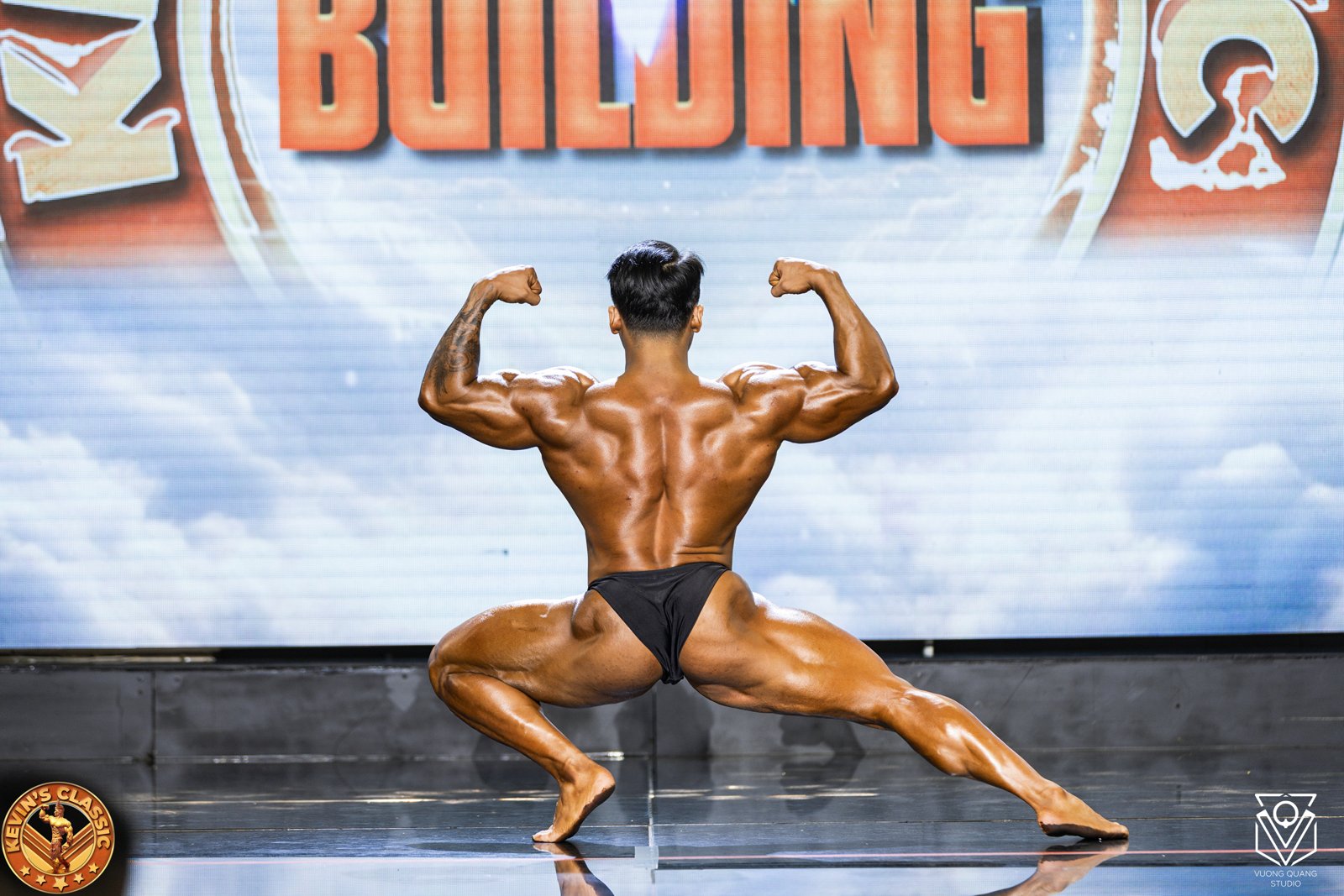 Vận động viên Bodybuilding mặc quần posing tạo tư thế gồng hai tay sau