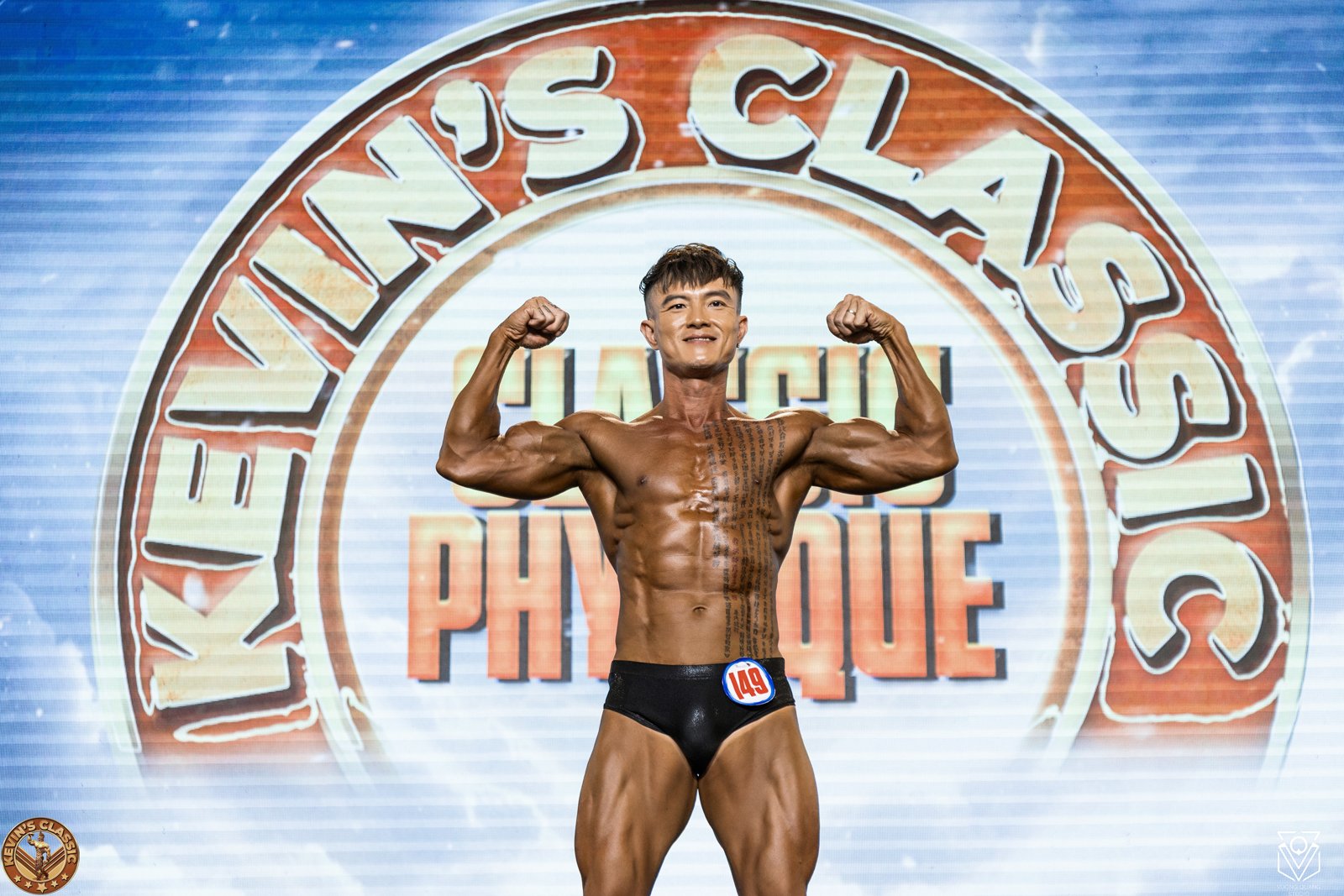 Vận động viên Classic Physique gồng hai tay trước phông chữ Classic Physique