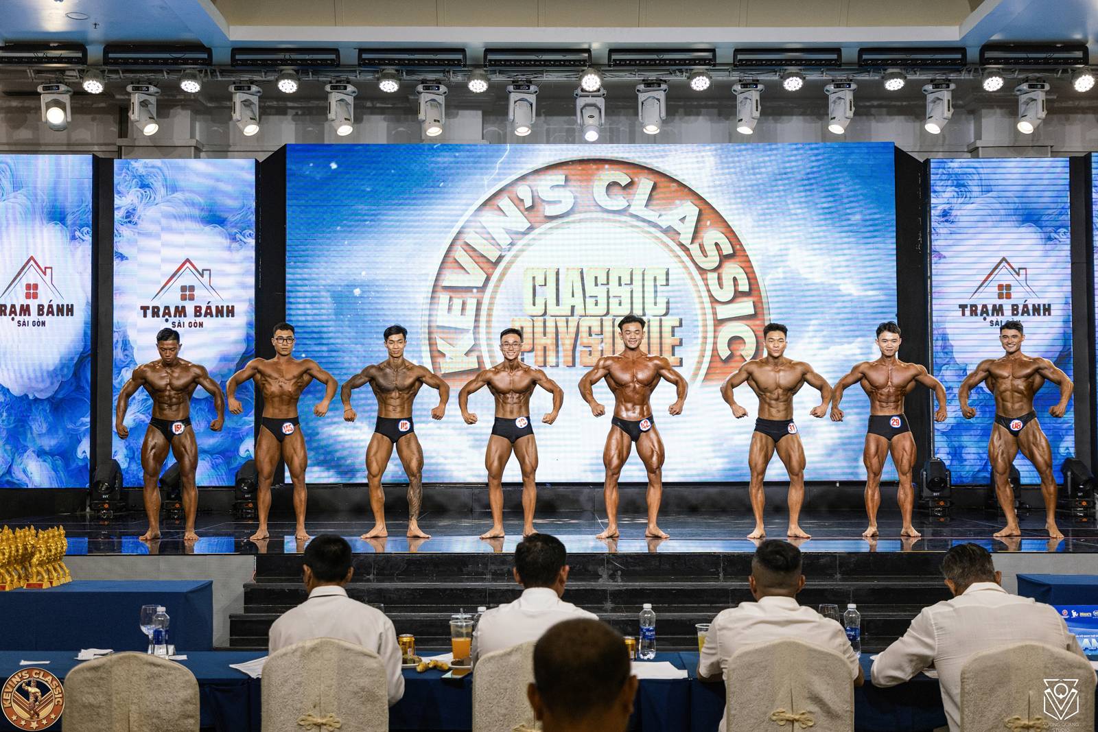 Vận động viên hạng Classic Physique so dáng trước bàn trọng tài tại giải Kevin's Classic 2026