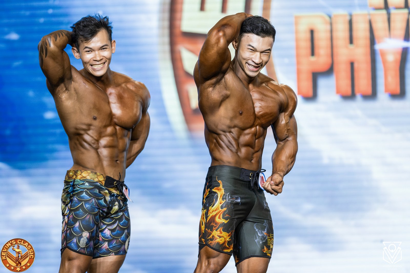 Hai vận động viên Men Physique mặc board shorts tạo dáng trên sân khấu