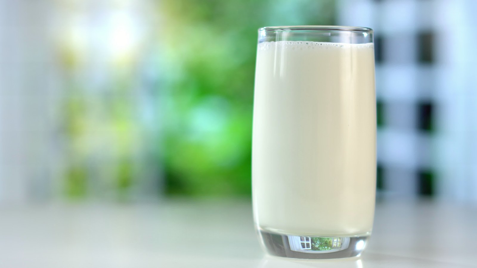 Một ly sữa tươi trắng đặt trên bàn