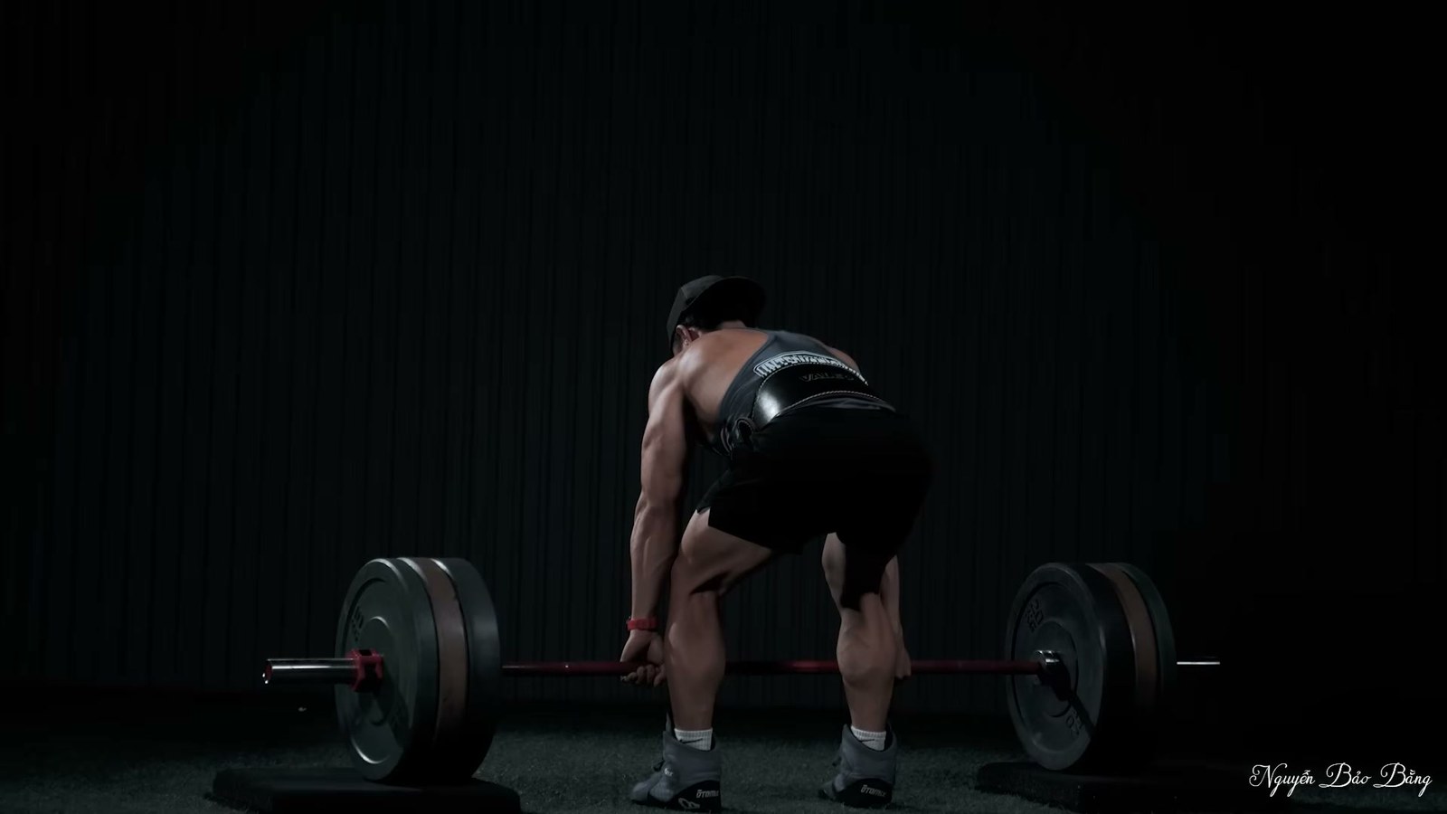 Nguyễn Bảo Bằng nâng tạ đòn với hông gập ra sau, tạ đi dọc trước đùi