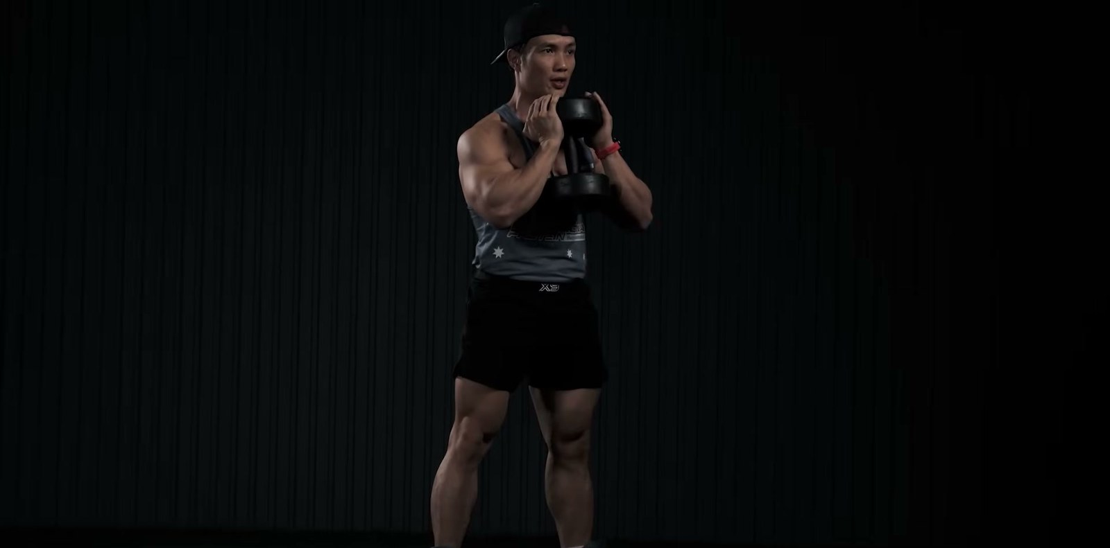 Nguyễn Bảo Bằng ôm tạ đơn trước ngực, tư thế chuẩn bị squat