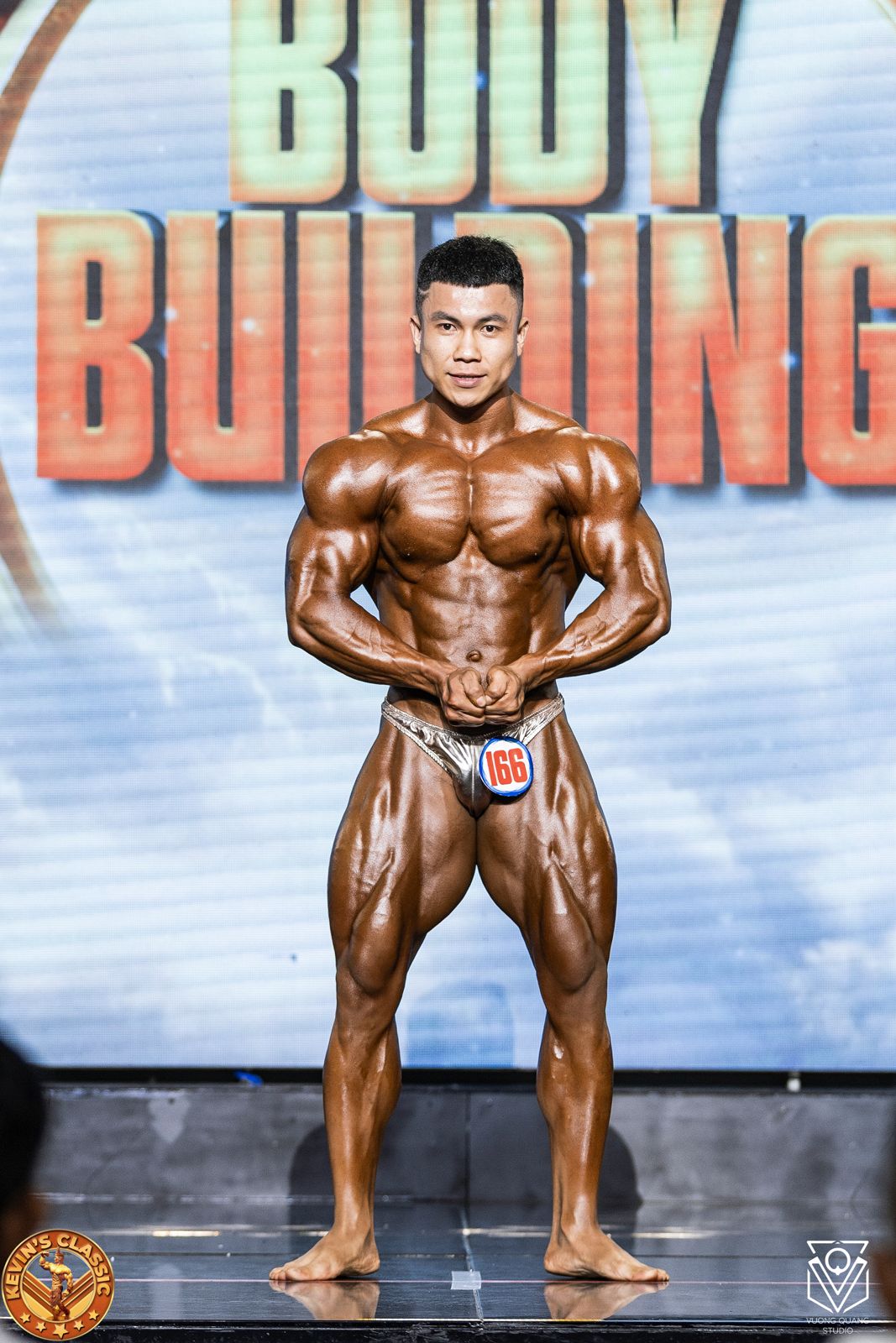 Vận động viên Bodybuilding tạo dáng trước phông chữ Body Building