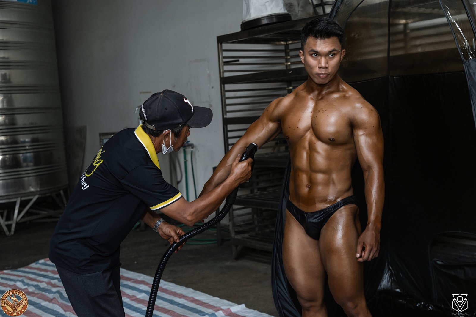 Vận động viên được phủ màu da bằng súng phun ở hậu trường