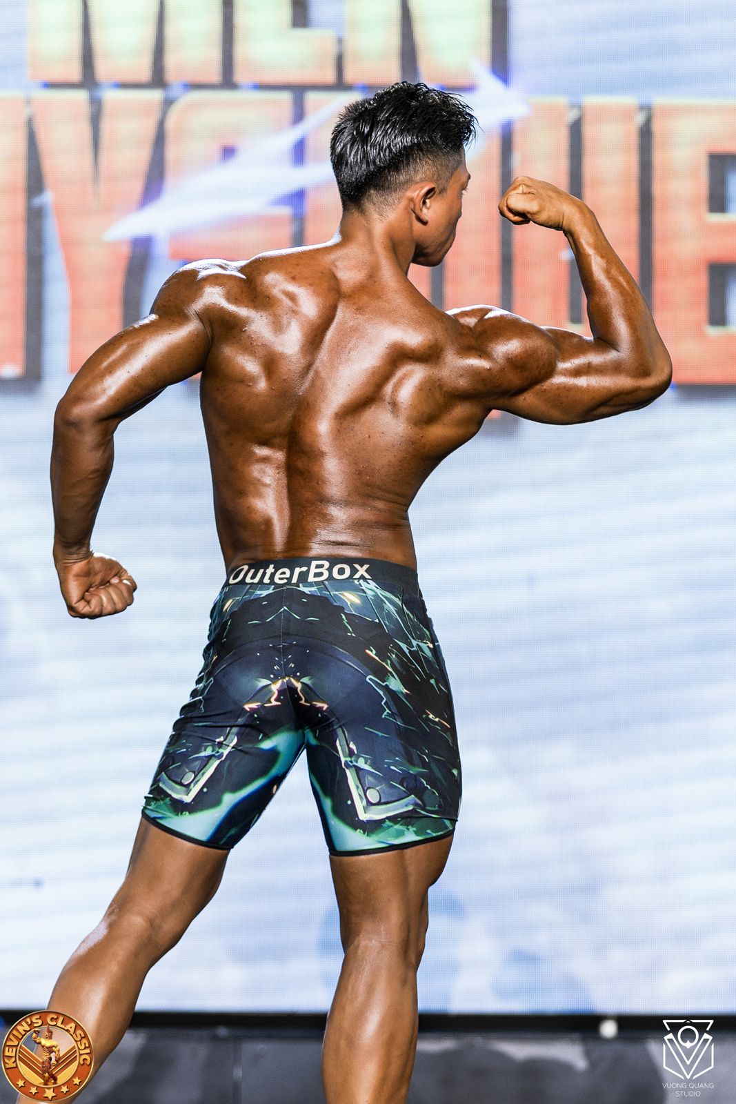 Vận động viên Men Physique gồng tay sau, lưng tách cơ