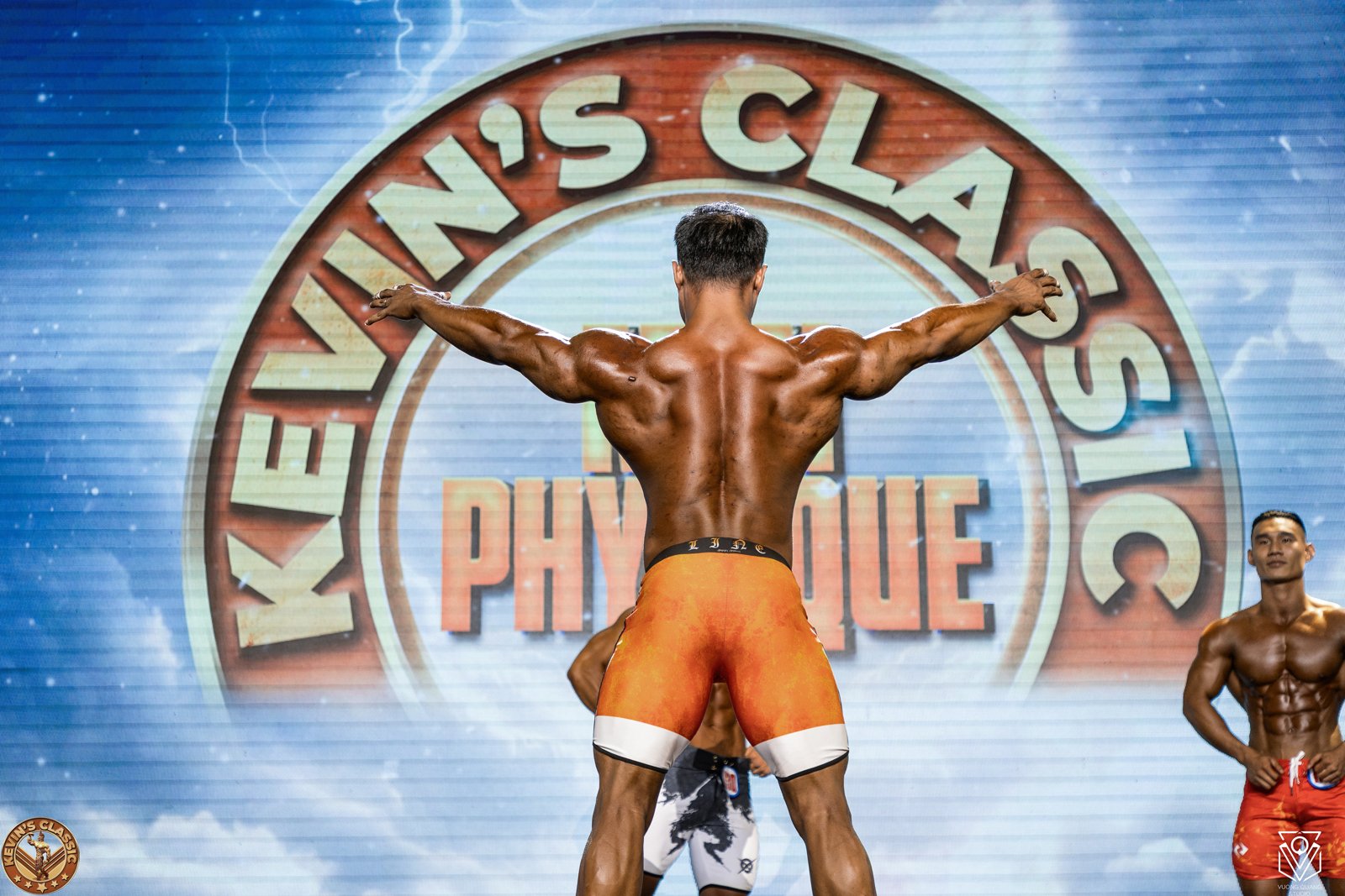 Vận động viên Men Physique mở rộng lưng trên sân khấu