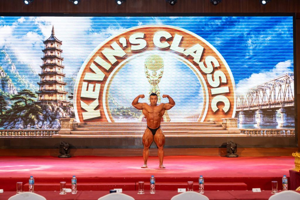 Một vận động viên biểu diễn trên sân khấu khai mạc, phía sau là phông Kevin’s Classic