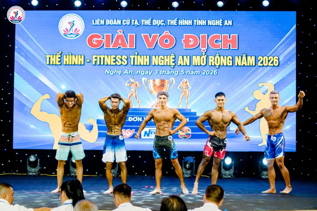 Năm vận động viên men's physique tạo dáng tay sau đầu tại giải thể hình Nghệ An 2026