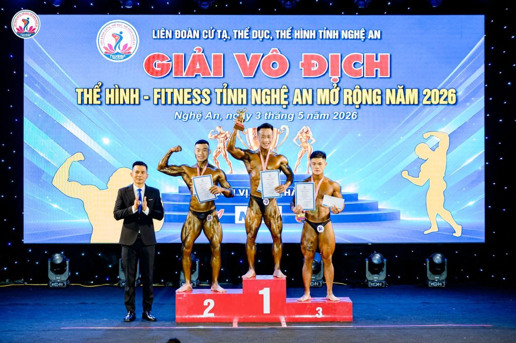 Ông Nguyễn Song Hào, Chủ tịch Liên đoàn Cử tạ, Thể dục, Thể hình tỉnh Nghệ An (trái), cạnh bục 1-2-3 buổi chiều – giải thể hình Nghệ An 2026