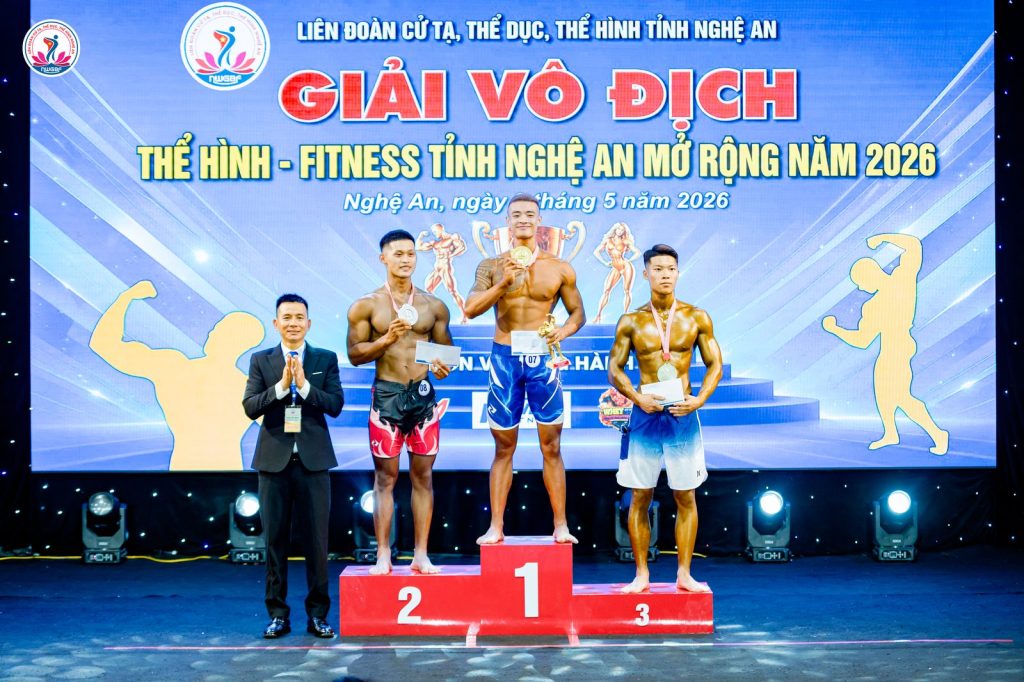 Ông Nguyễn Song Hào, Chủ tịch Liên đoàn Cử tạ, Thể dục, Thể hình tỉnh Nghệ An (trái), cạnh bục 1-2-3 một nội dung men's physique – giải thể hình Nghệ An 2026