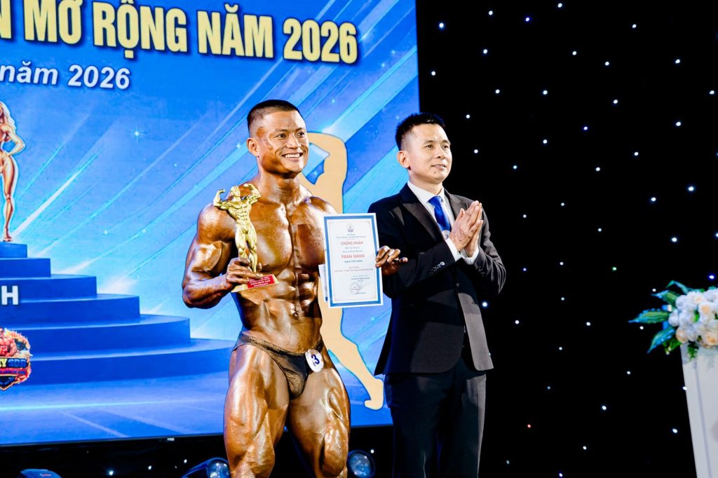 Ông Nguyễn Song Hào, Chủ tịch Liên đoàn Cử tạ, Thể dục, Thể hình tỉnh Nghệ An, cùng vận động viên cầm cúp – giải thể hình Nghệ An 2026