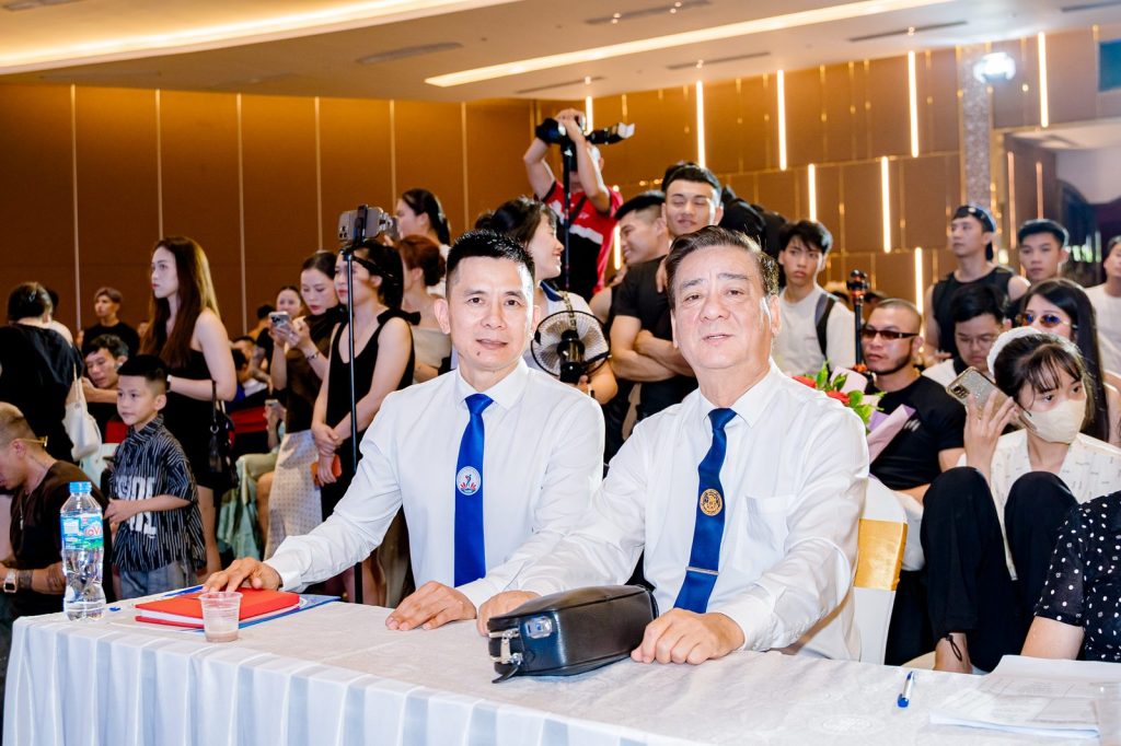 Ông Nguyễn Song Hào, Chủ tịch Liên đoàn Cử tạ, Thể dục, Thể hình tỉnh Nghệ An (trái, sơ mi trắng), ngồi bàn cùng một đại biểu – giải thể hình Nghệ An 2026