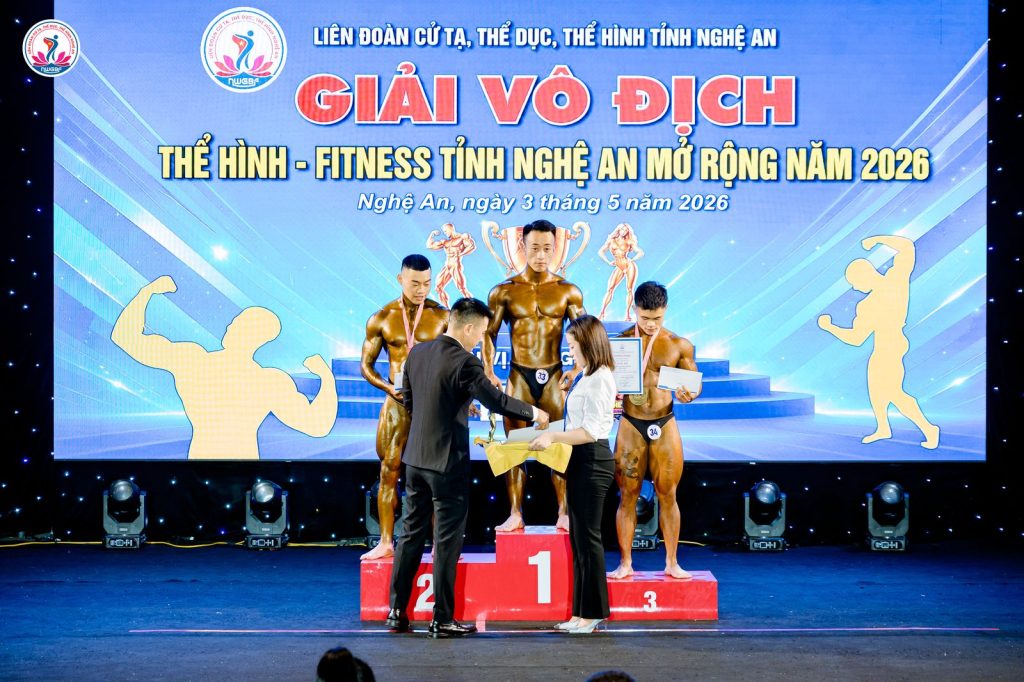 Ông Nguyễn Song Hào, Chủ tịch Liên đoàn Cử tạ, Thể dục, Thể hình tỉnh Nghệ An, trao huy chương cho vận động viên thể hình trên bục – giải thể hình Nghệ An 2026