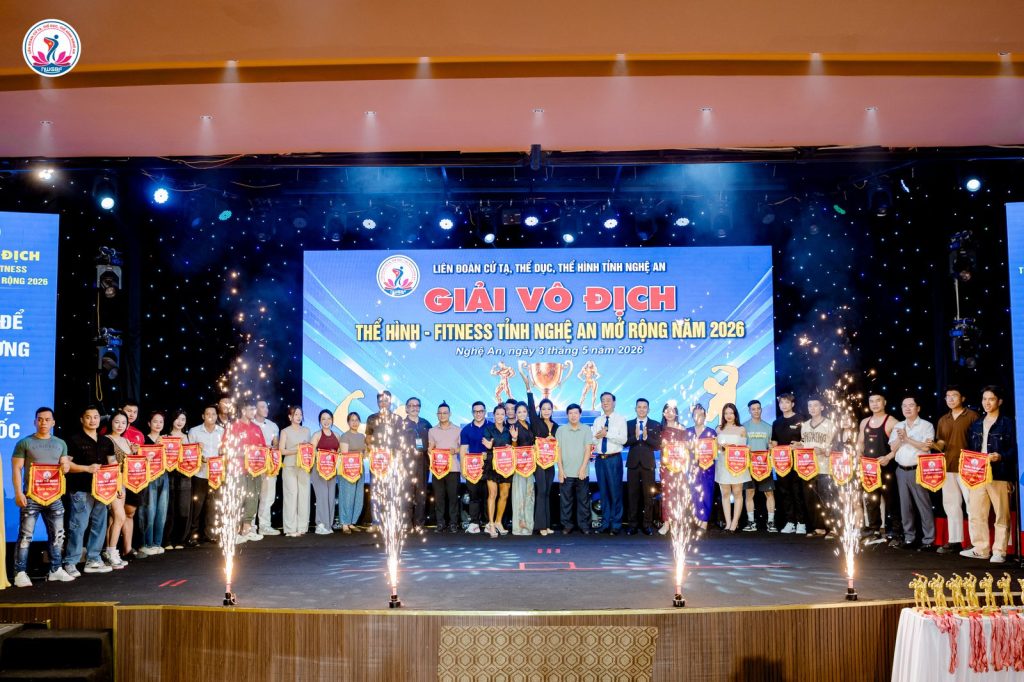 Ông Nguyễn Song Hào (giữa) cùng đại diện các đoàn nhận cờ lưu niệm tại lễ khai mạc giải thể hình Nghệ An 2026