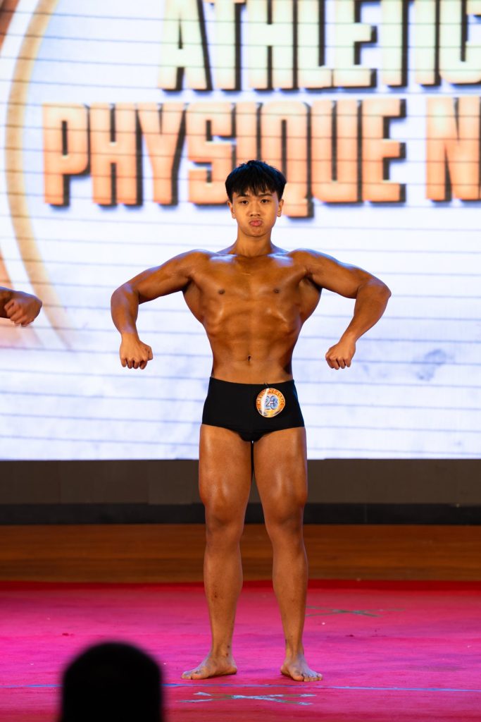 Vận động viên trẻ mở xô trước, phía sau là phông chữ Athletic Physique Nam