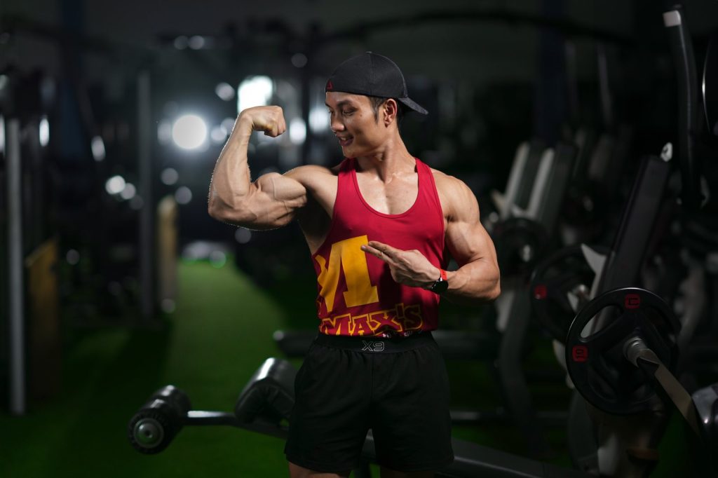 Nguyễn Bảo Bằng gồng bắp tay trong phòng tập buổi tối