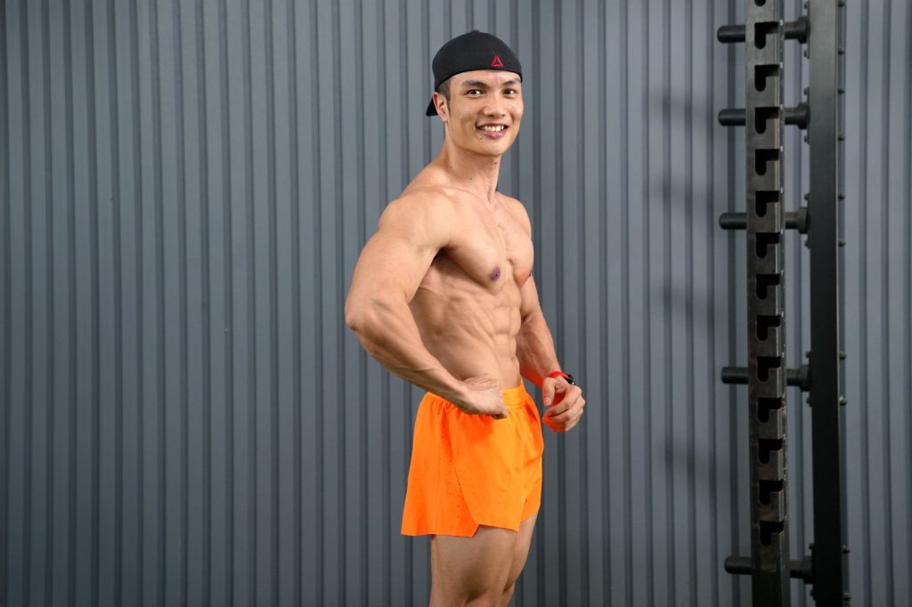 Nguyễn Bảo Bằng gồng ngực nghiêng, quần cam